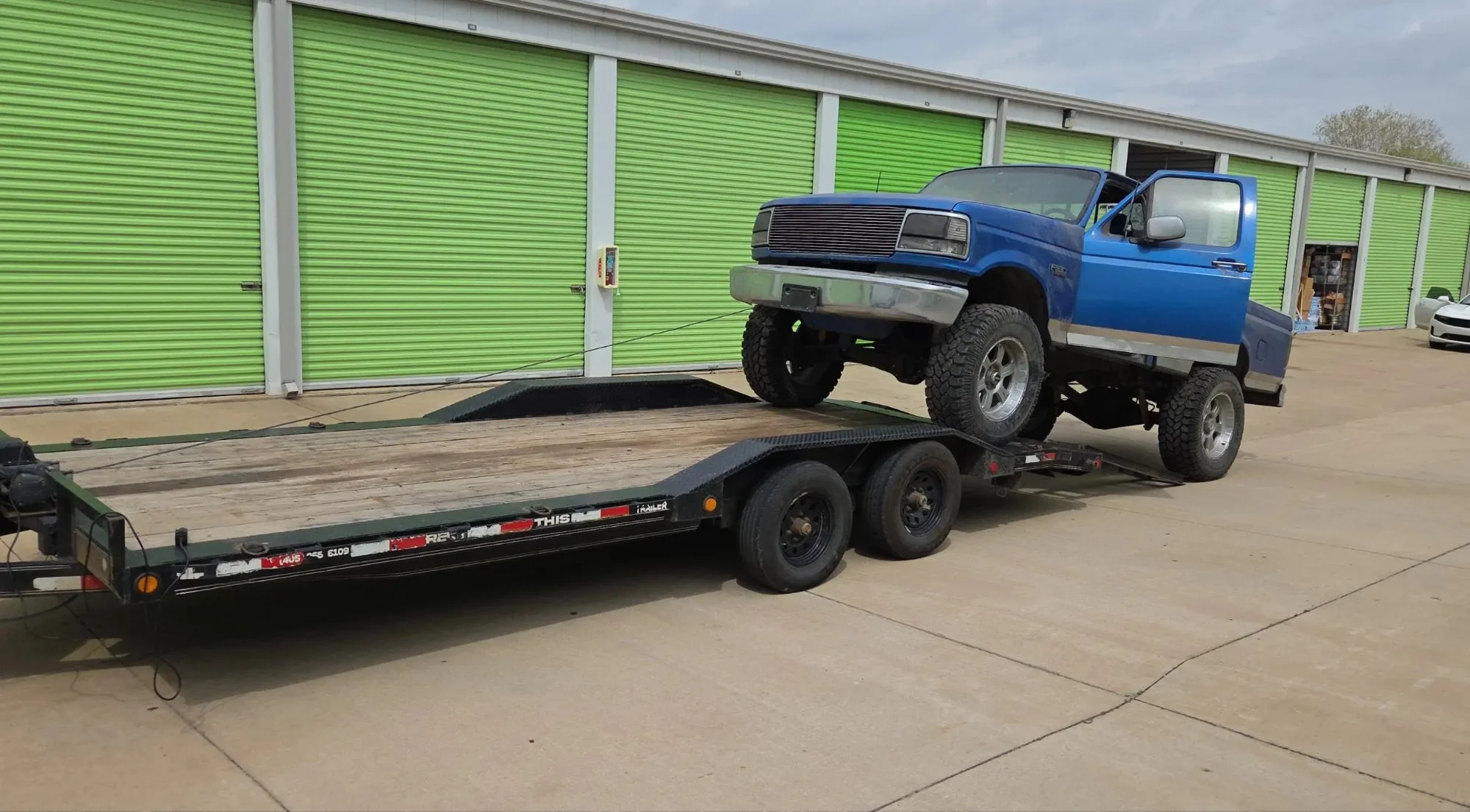 Lifted Ford truck loading on car hauler rental Yukon OK